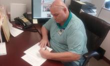 Bill Garrity signs the UHP contract continuation agreement.