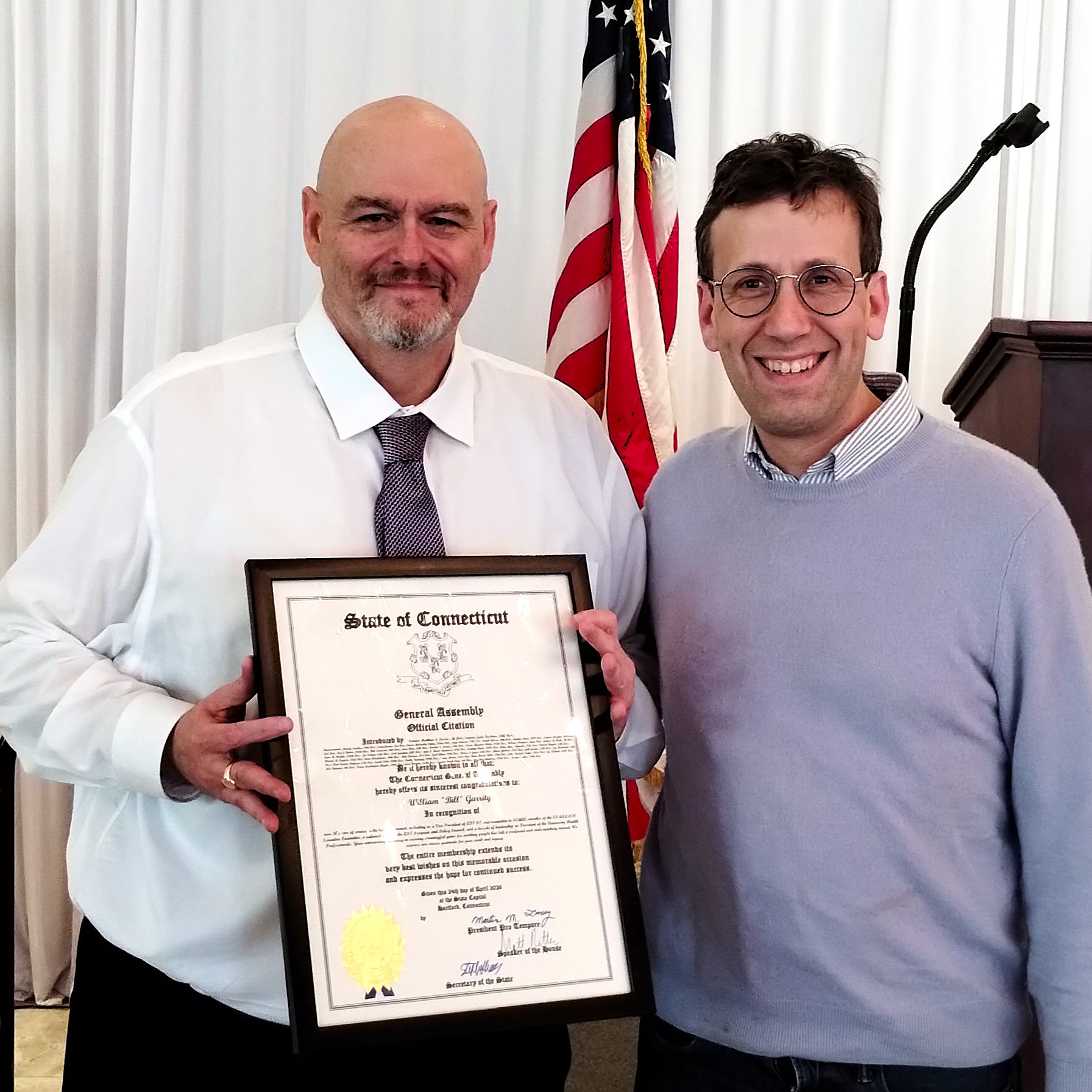 Sen. Matt Lesser presents President Bill Garrity with a legislative proclamation.