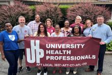 group portrait holding UHP banner