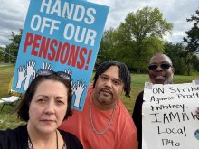 three people on picket line with signs